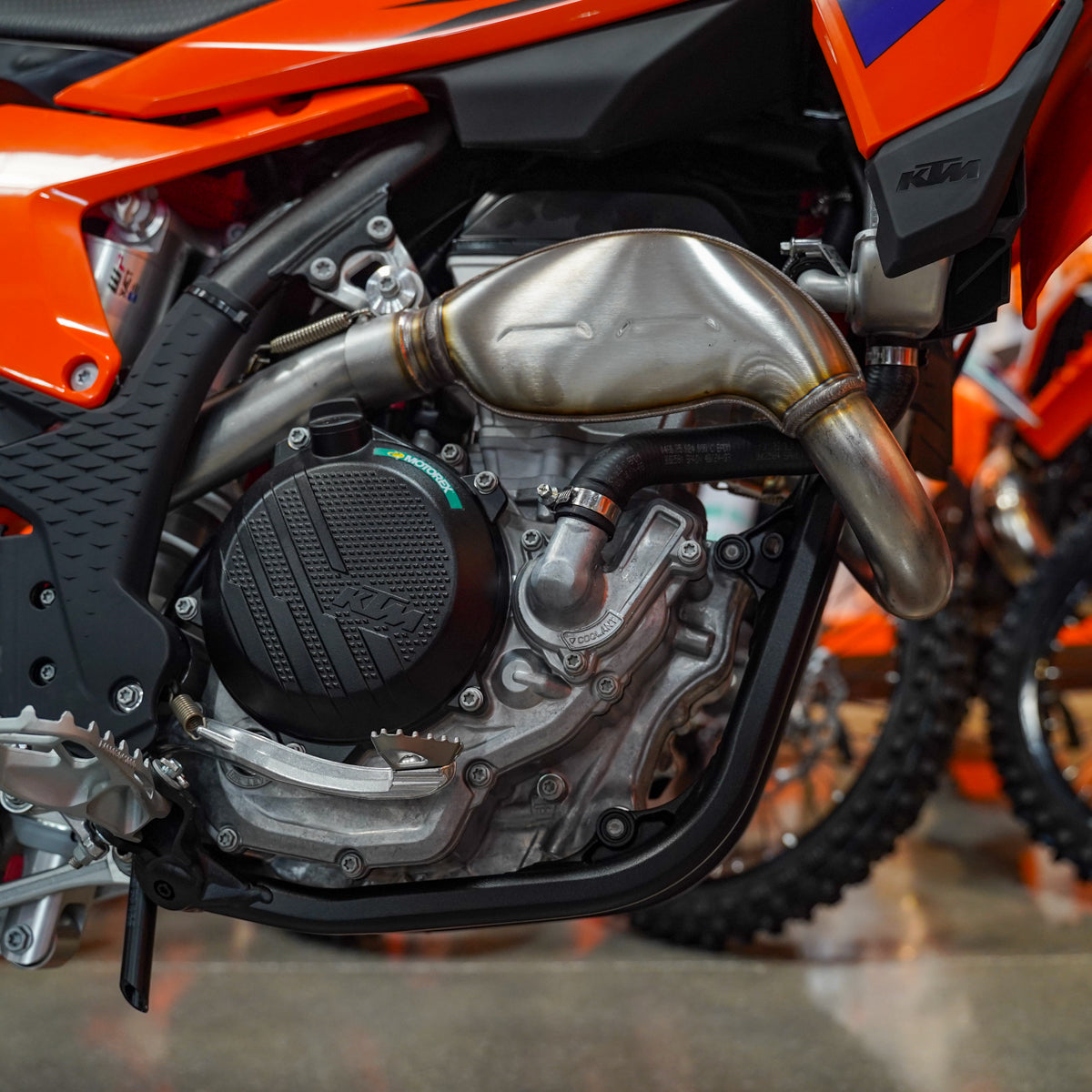 Close-up of a motorcycle engine with visible branding in a showroom setting