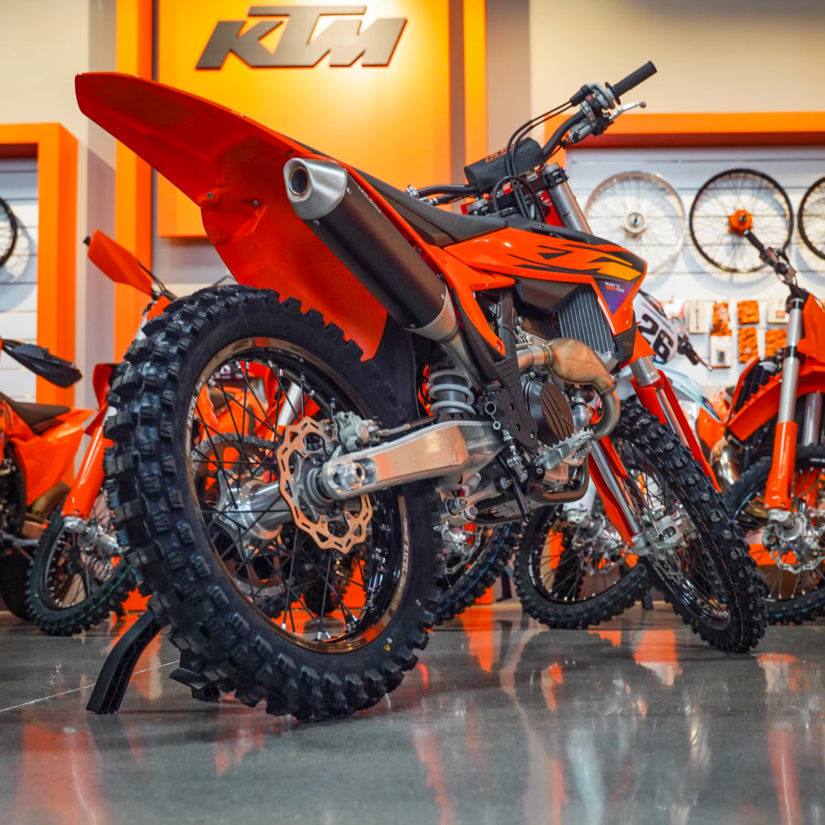 Orange KTM dirt bike in a showroom setting - KTM 250 SX-F Back diagonal view
