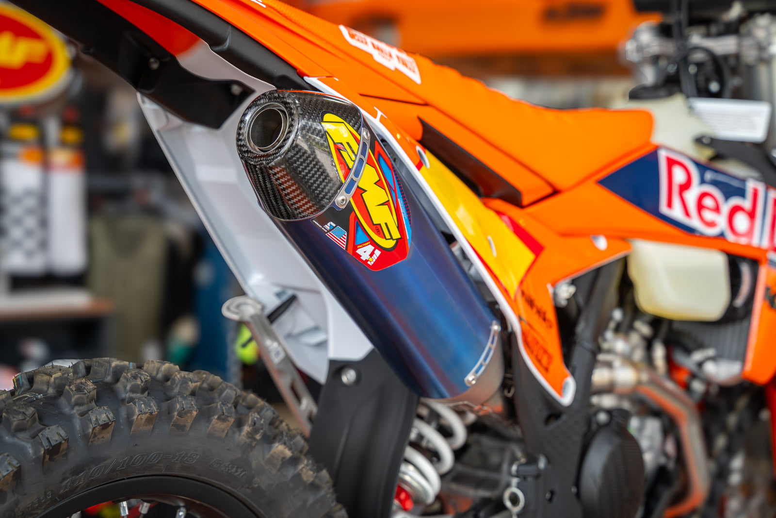 Close-up of a dirt bike with visible branding in a workshop setting featuring FMF 4.1 Exhaust on the custom KTM 500 XW-F Rally Build
