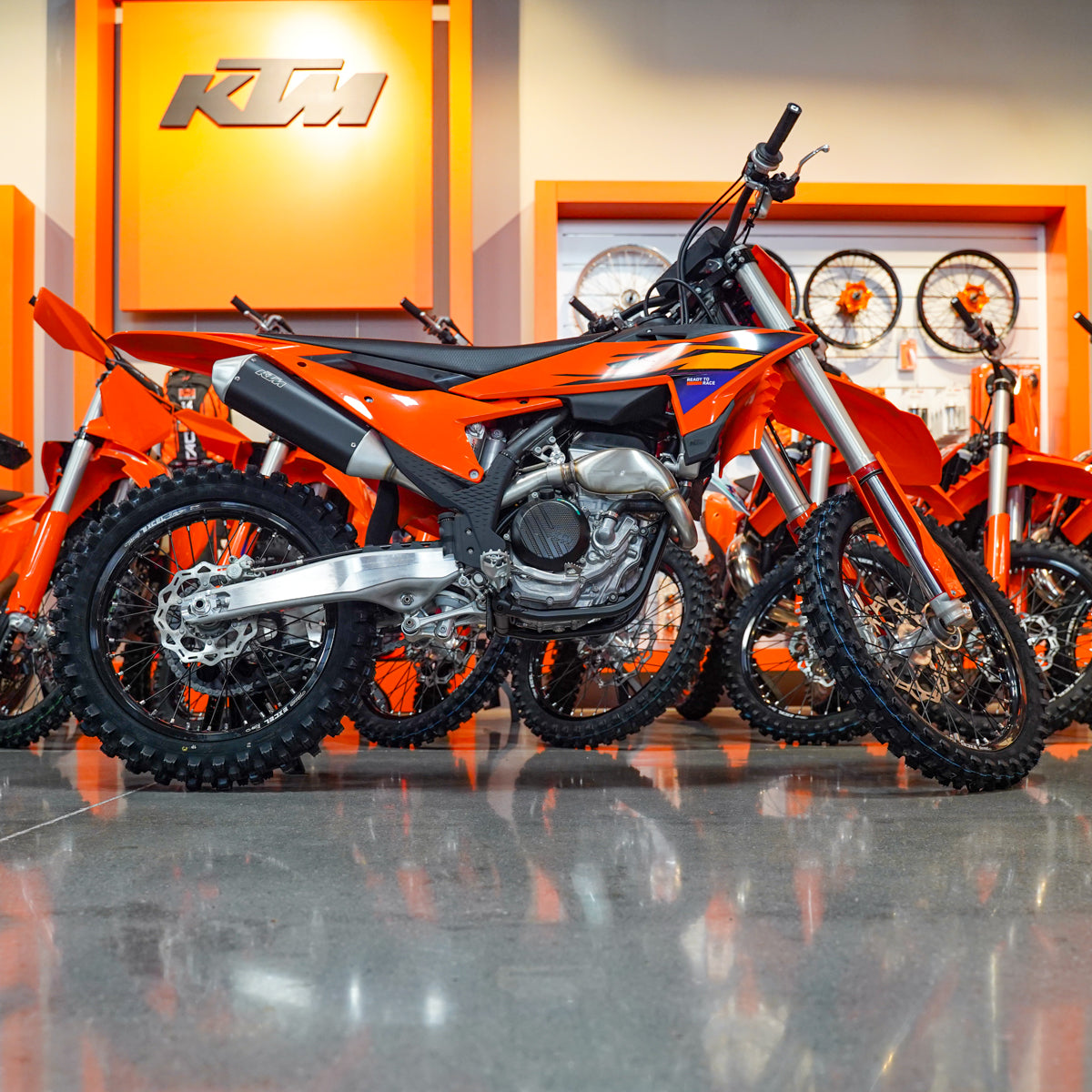 Orange KTM dirt bike on display in a showroom.