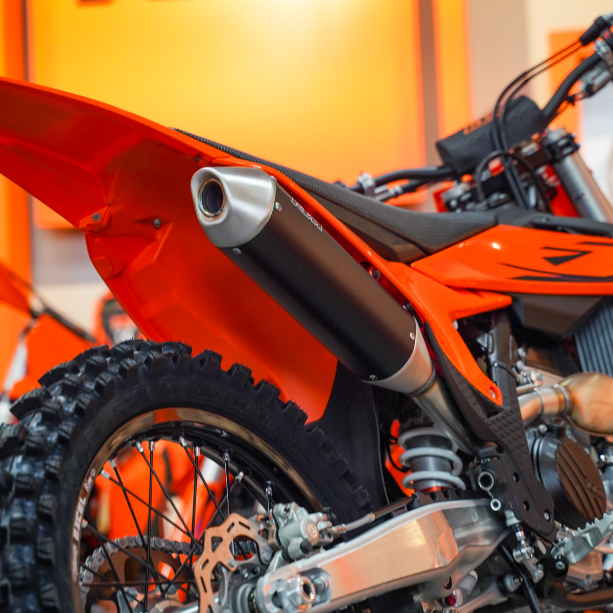 Close-up of an orange dirt bike with a blurred background